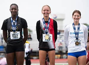 Three students wearing medals around their necks