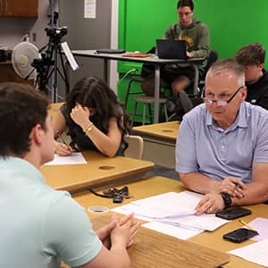 students and an adult sitting at desks