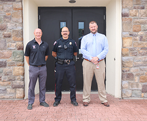 Three men in front of school building