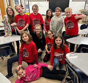 Group of happy elementary students in the classroom