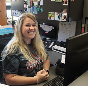 Women smiling from her desk