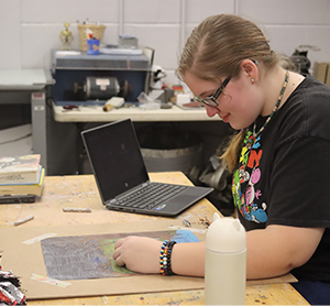 Girl sitting at her desk with a computer